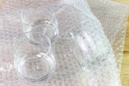 Foto de El vidrio de agua de la cubierta de la envoltura de burbuja en la caja para el producto de protección - Imagen libre de derechos