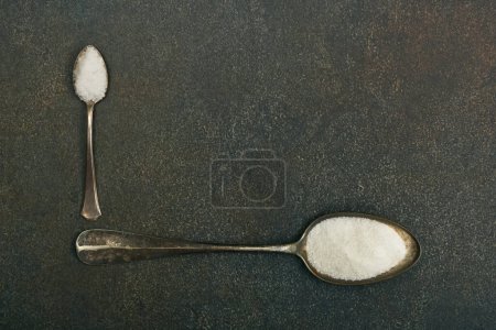 Foto de Dos cucharadas de azúcar y sal en la mesa - Imagen libre de derechos