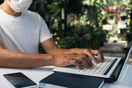 Téléchargez les photos : Un homme travaillant à la maison et utilisant un ordinateur portable sur la table. Technologie - en image libre de droit