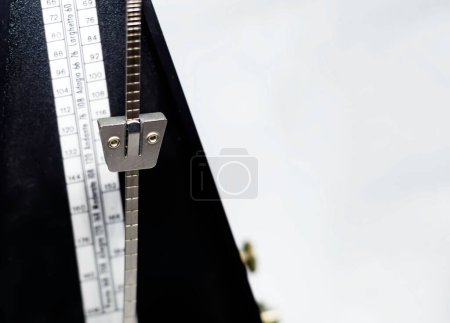 Téléchargez les photos : Détail du pendule d'un métronome classique. Outil de mesure du rythme. - en image libre de droit