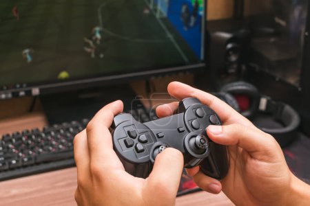 Téléchargez les photos : L'homme tient un joystick de jeu dans ses mains tout en jouant à un jeu vidéo - en image libre de droit