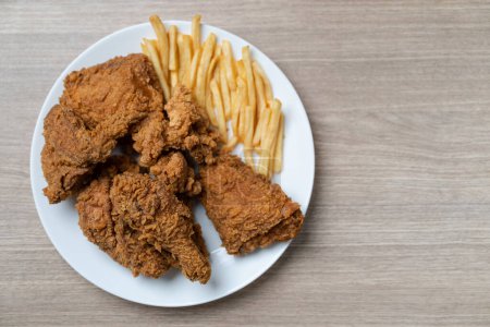 Photo for Crispy fried chicken with french fries in white plate on a wooden table - Royalty Free Image