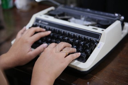 Téléchargez les photos : Gros plan sur les mains féminines tapant sur la machine à écrire. - en image libre de droit