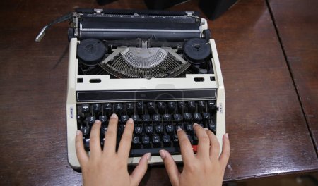 Foto de Primer plano en las manos femeninas escribiendo en el tipo de escritor. - Imagen libre de derechos
