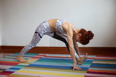 Téléchargez les photos : Femme pratique le yoga à la maison - en image libre de droit