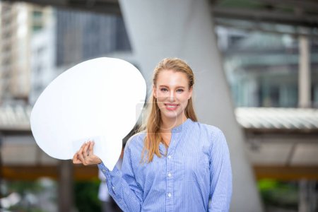 Téléchargez les photos : "Femmes d'affaires avec main tenant tableau blanc sur fond flou" - en image libre de droit