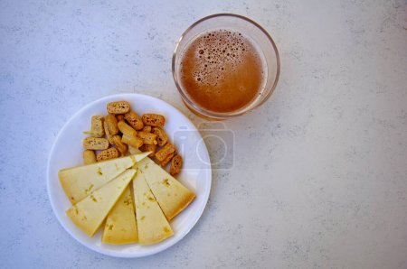 Photo for One glass of beer and snacks, center, atop - Royalty Free Image