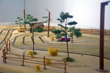 Foto de Pequeña casa de juguete, coche rojo, árboles y linterna en pista de juguete - Imagen libre de derechos