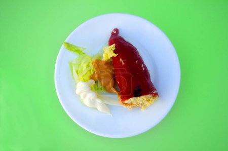 Téléchargez les photos : Papier farci rouge avec salade et sauce sur assiette blanche - en image libre de droit