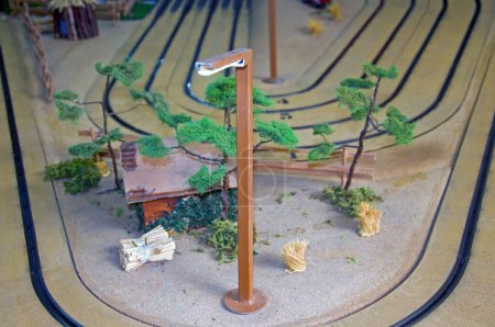 Foto de Pequeña casa de juguete, árboles y linterna en pista de juguete - Imagen libre de derechos