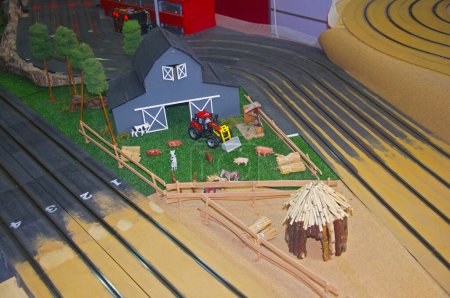 Téléchargez les photos : Petit parc de jouets gris, tracteur rouge et grange en bois - en image libre de droit
