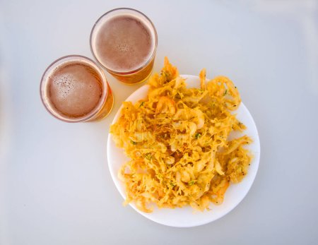 Photo for Fried yellow fritters with small shrimps and two beers - Royalty Free Image