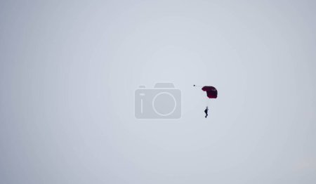 Photo for Silhouette parachute stunt unfocused and blurry while gliding in the air - Royalty Free Image