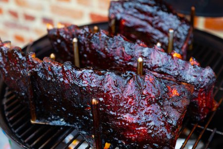 Téléchargez les photos : "Côtes de rechange vitrées cerise dans un rack sur le barbecue" - en image libre de droit