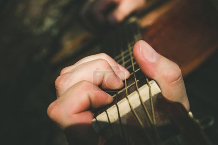 Foto de "Dedos formando un acorde en un diapasón de guitarra. Mano masculina tocando la guitarra. Enfoque selectivo
" - Imagen libre de derechos