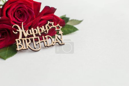 Foto de "Composición de ramo de rosas rojas y saludo decorativo de madera sobre fondo blanco. Feliz Cumpleaños. Espacio para texto." - Imagen libre de derechos