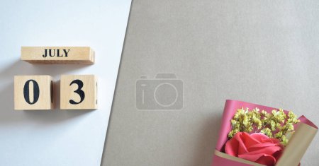 Foto de Calendario de madera con mes de julio y ramo de flores de rosa - Imagen libre de derechos