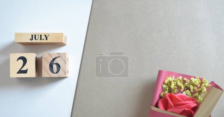 Téléchargez les photos : Calendrier en bois avec mois de juillet et bouquet de fleurs de rose - en image libre de droit