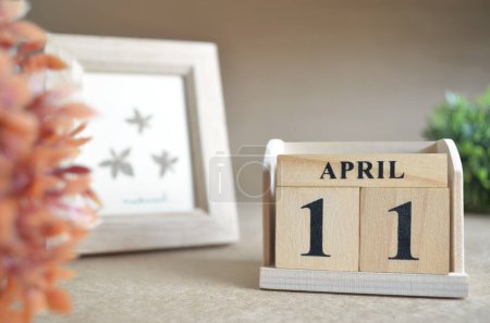 Photo for Wooden calendar with month of april and picture frame - Royalty Free Image