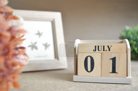 Téléchargez les photos : Calendrier en bois avec mois de juillet et cadre photo - en image libre de droit