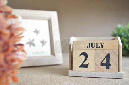 Photo for Wooden calendar with month of July and picture frame - Royalty Free Image