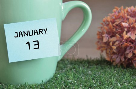 Téléchargez les photos : "gros plan de la tasse, note collante avec inscription 13 janvier." - en image libre de droit