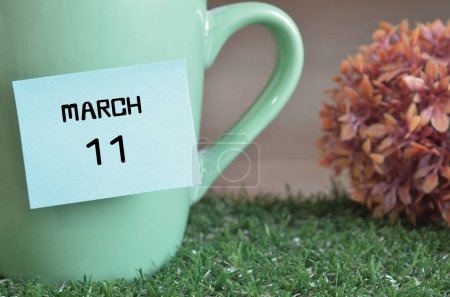 Téléchargez les photos : "plan rapproché de la tasse, note collante avec inscription 11 mars." - en image libre de droit