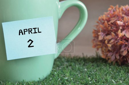 Téléchargez les photos : "gros plan de la tasse, note collante avec inscription 2 avril." - en image libre de droit