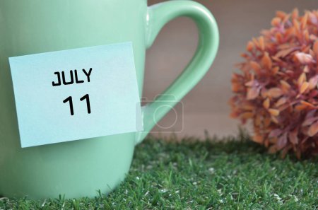 Téléchargez les photos : "gros plan de la tasse, note collante avec inscription 11 juillet." - en image libre de droit