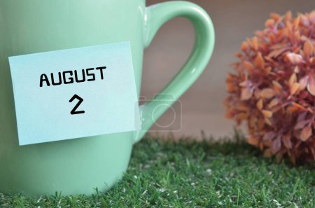 Téléchargez les photos : "gros plan de la tasse, note collante avec inscription 2 août." - en image libre de droit