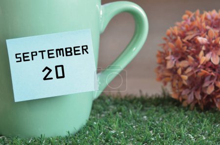 Photo for "close-up shot of cup, sticky note with inscription September 20" - Royalty Free Image