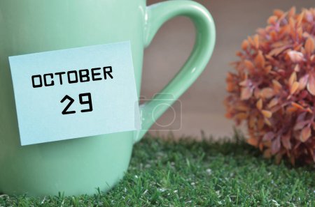 Foto de Taza de color menta con palo de papel y fecha mes de octubre - Imagen libre de derechos