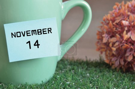 Foto de Taza de color menta con palo de papel y fecha mes de noviembre - Imagen libre de derechos