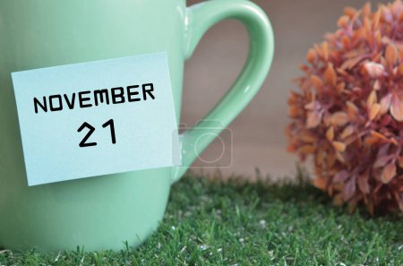 Foto de Taza de color menta con palo de papel y fecha mes de noviembre - Imagen libre de derechos