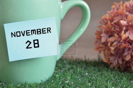 Téléchargez les photos : Tasse de couleur menthe avec bâton de papier et Novembre mois date - en image libre de droit