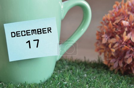 Téléchargez les photos : Tasse à menthe avec date et mois de décembre sur la surface de l'herbe - en image libre de droit