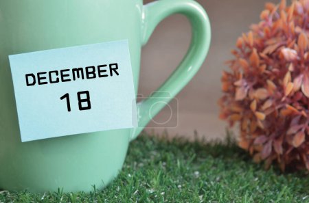 Foto de Taza de color menta con palo de papel y la fecha del mes de diciembre - Imagen libre de derechos