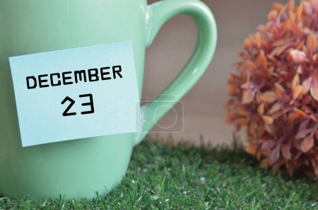 Foto de Taza de color menta con palo de papel y la fecha del mes de diciembre - Imagen libre de derechos
