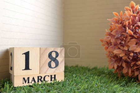 Photo for Wooden calendar with month of March and green grass - Royalty Free Image