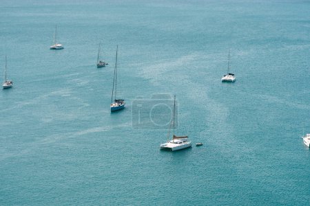 Foto de PHUKET, TAILANDIA - 15 DE MAYO DE 2020: Yates de vela y catamaranes están estacionados en el puerto de la isla de Nai Harn Bay Phuket. - Imagen libre de derechos