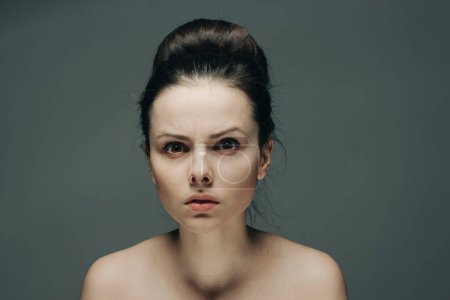 Téléchargez les photos : Femme émotionnelle peau propre cosmétologie coiffure gris fond modèle - en image libre de droit
