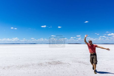 Photo for "young man having fun on a salt lake and smiling in camera on a salt lake inwestern australia" - Royalty Free Image