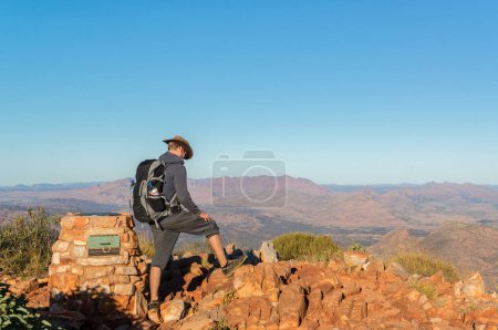 Photo for "man enjoying view after a hike to the top of Mount Sonder just outside Alice Springs, West MacDonnel National Park, Australia" - Royalty Free Image