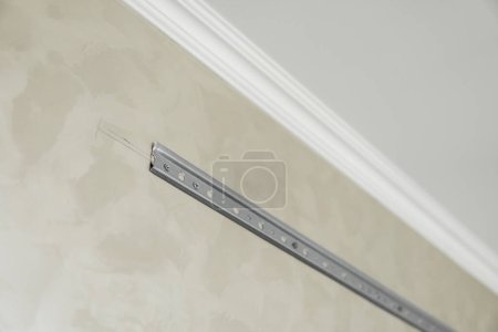 Photo for Close-up of stainless steel mounting rail for mounting kitchen cabinets on a wall. - Royalty Free Image