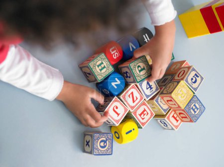Téléchargez les photos : Fille avec des cubes colorés sur le sol - en image libre de droit