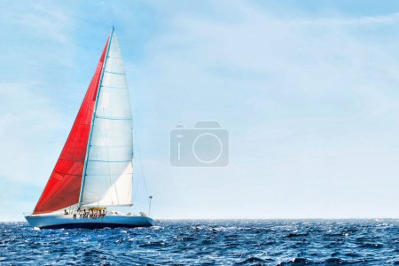 Téléchargez les photos : Voilier dans l'océan bleu paisible contre le ciel - en image libre de droit