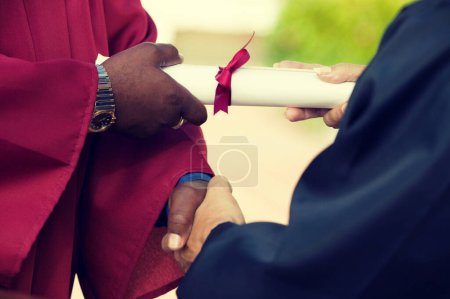 Foto de Diploma y apretón de manos para graduados - Imagen libre de derechos