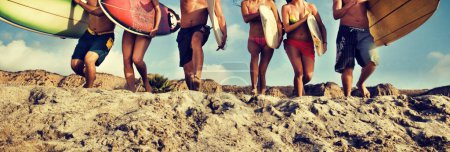 Foto de Grupo de amigos multiétnicos con tablas de surf en la playa de arena - Imagen libre de derechos