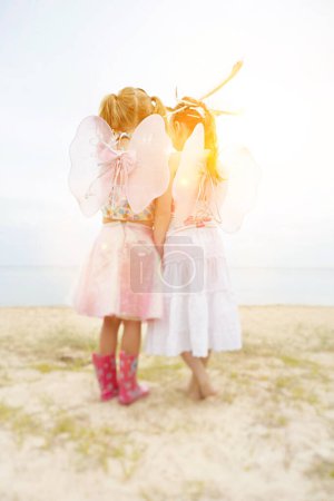 Foto de Dos niñas con alas rosadas en verano - Imagen libre de derechos
