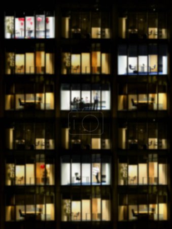 Téléchargez les photos : Photo floue de l'immeuble de bureaux la nuit - en image libre de droit